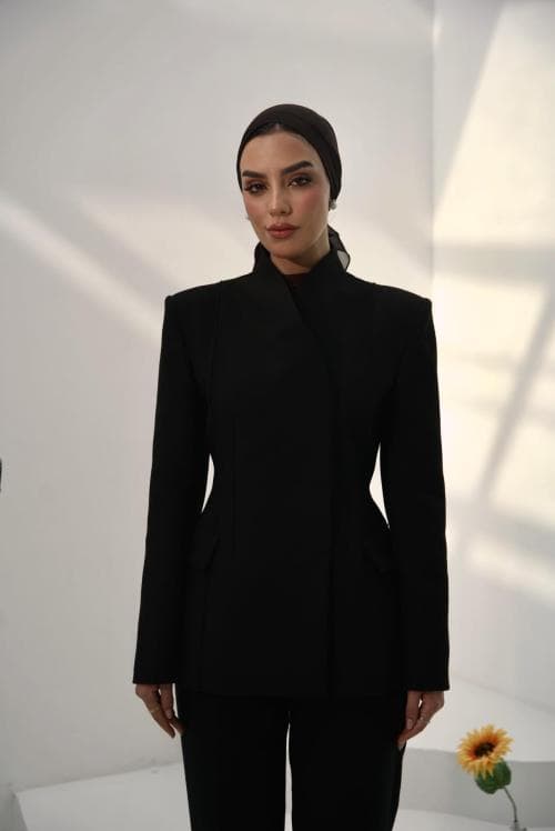 ISHRAQ BRAHMI wearing a black suit in a naturally lit studio